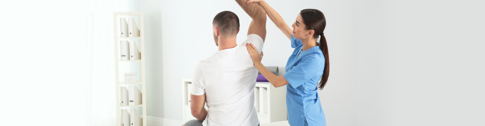 woman physiotherapist helping a patient to exercise