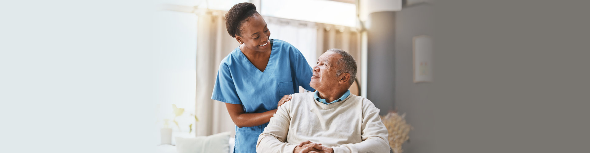 smiling female caregiver checking up on senior man