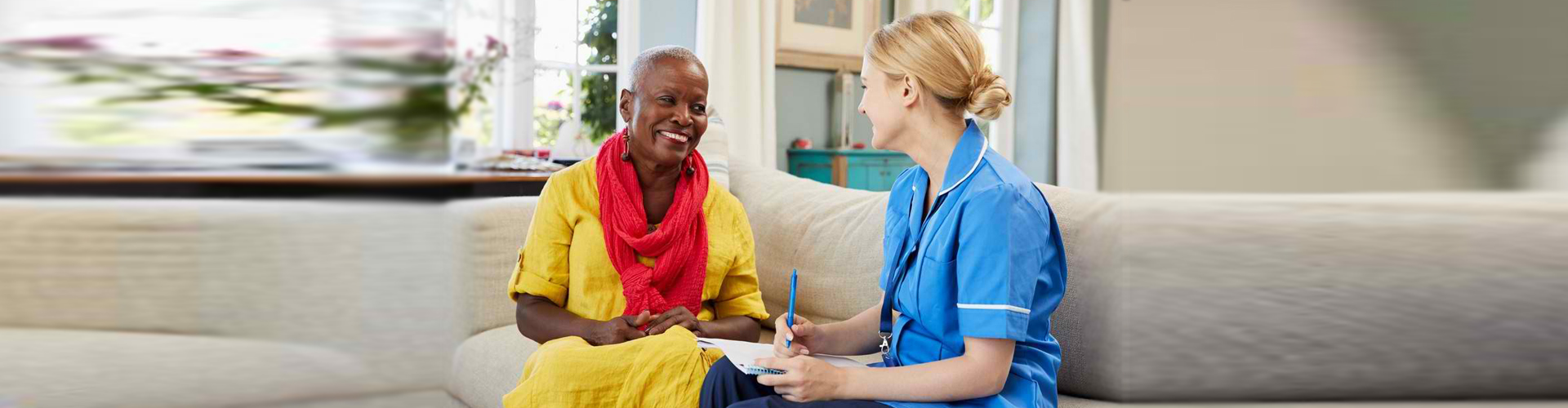 a female caregiver talking to an elderly woman